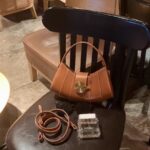 Vintage - inspired Rustic Caramel Leather Crescent Handbag with Ornate Golden Swirl Lock